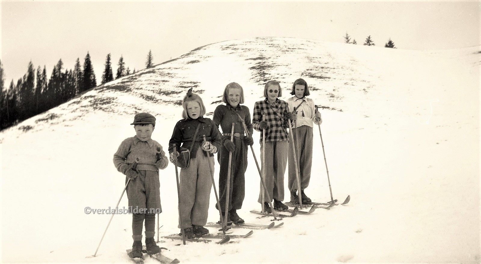 Tidsbilde som viser barns skiutstyr like etter krigen. På den tid måtte en lage løyper og hoppbakker selv. Det var ingen foreldre som &quot;jåggå&quot; på sine avkom i konkuranser på den tid. Kanskje ha barna det &quot;artiar&quot; på ski da enn nu. Utlånt med navna av Terje Reitan.